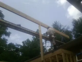 Carpenter setting a ridge beam over a new addition frame — Ice Dam Removal by Roofing Brothers in Harrison City
