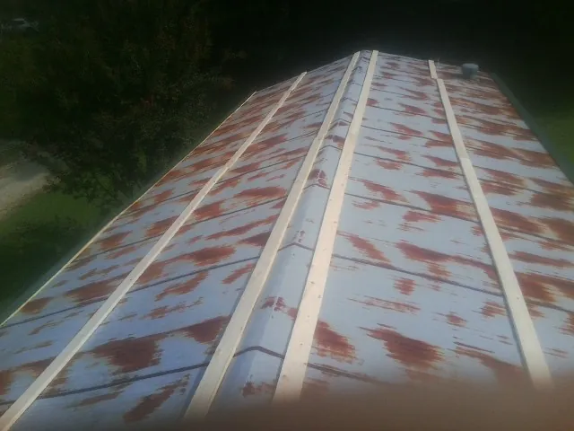 Rusted metal roof panels with new wood purlins before replacement — Storm Damage Roof Repair in Harrison City by Roofing Brothers