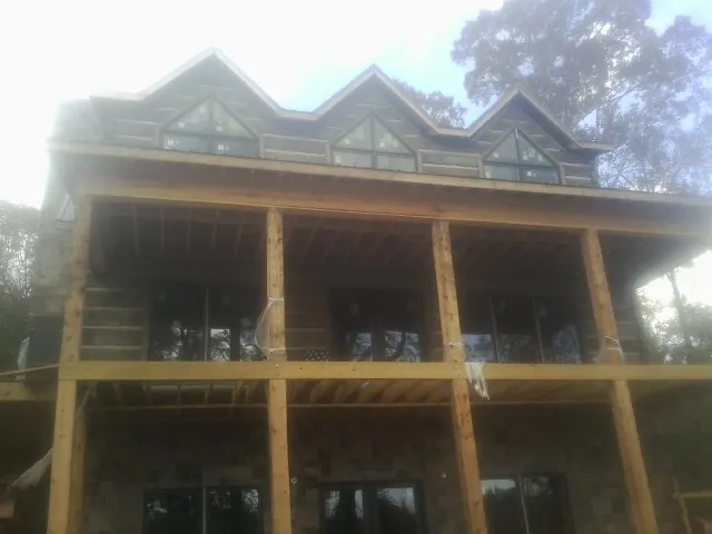 Dormers and porch framing on a large log home under construction — Roof Coating work by our crew in Harrison City