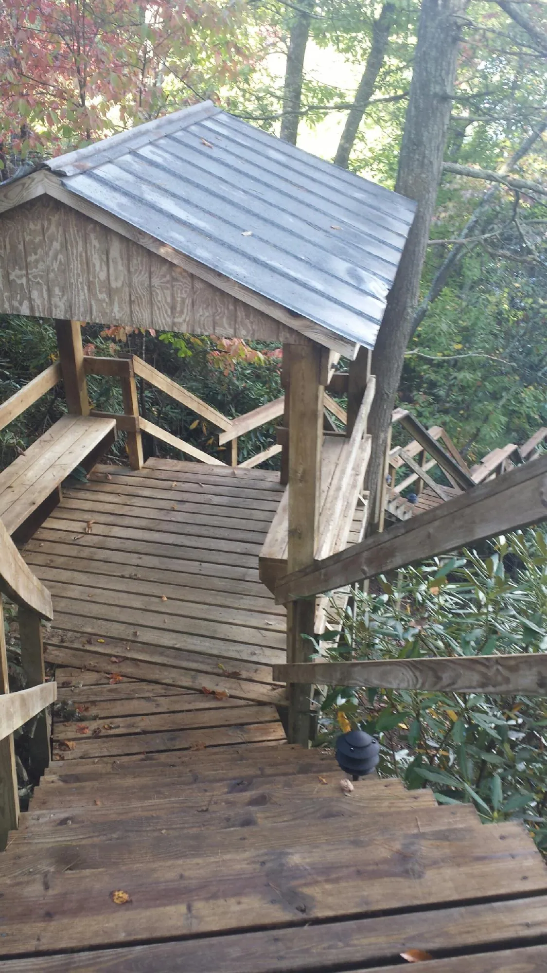 Metal roofed shelter over wooden steps on a wooded walkway — Skylight Repair & Installation work by our crew in Harrison City