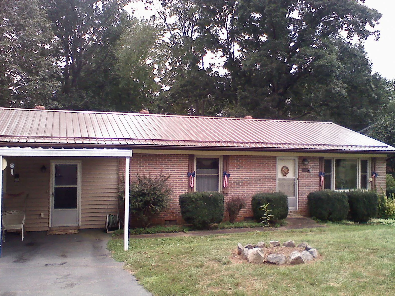 Bronze metal roof and carport on a brick ranch home — Roof Repair work by our crew in Harrison City